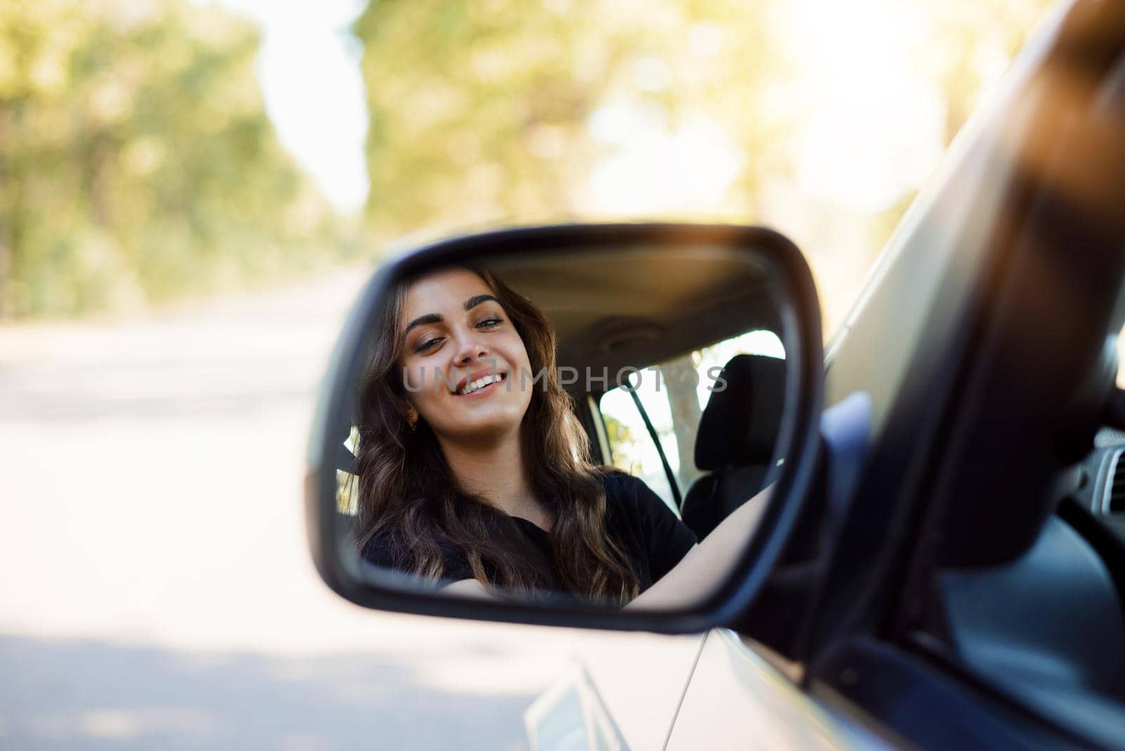 Young girl driver through the rearview mirror by VitaliiPetrushenko