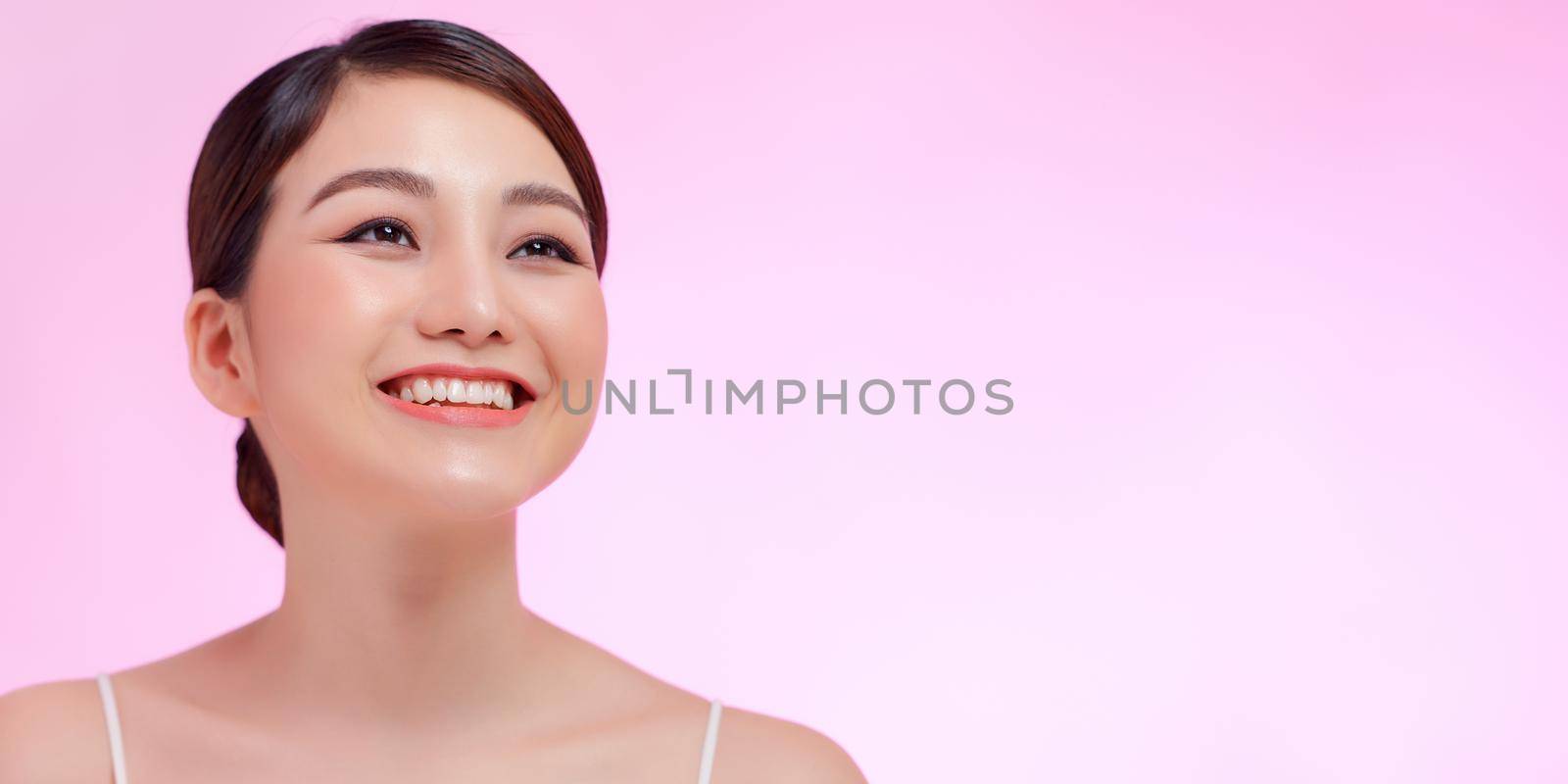 Beautiful woman face close up studio on pink. by makidotvn