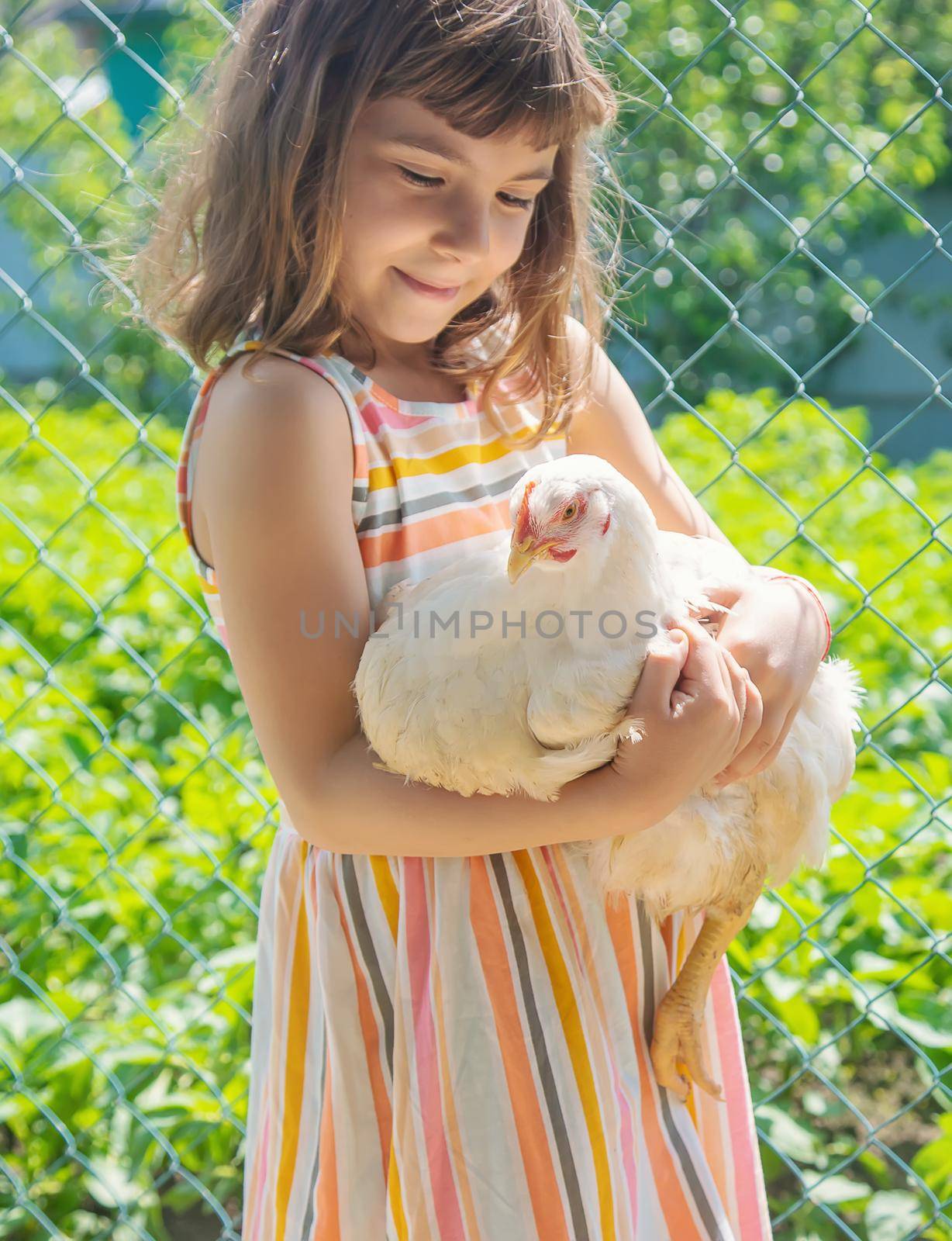 A child on a farm with a chicken. Selective focus.