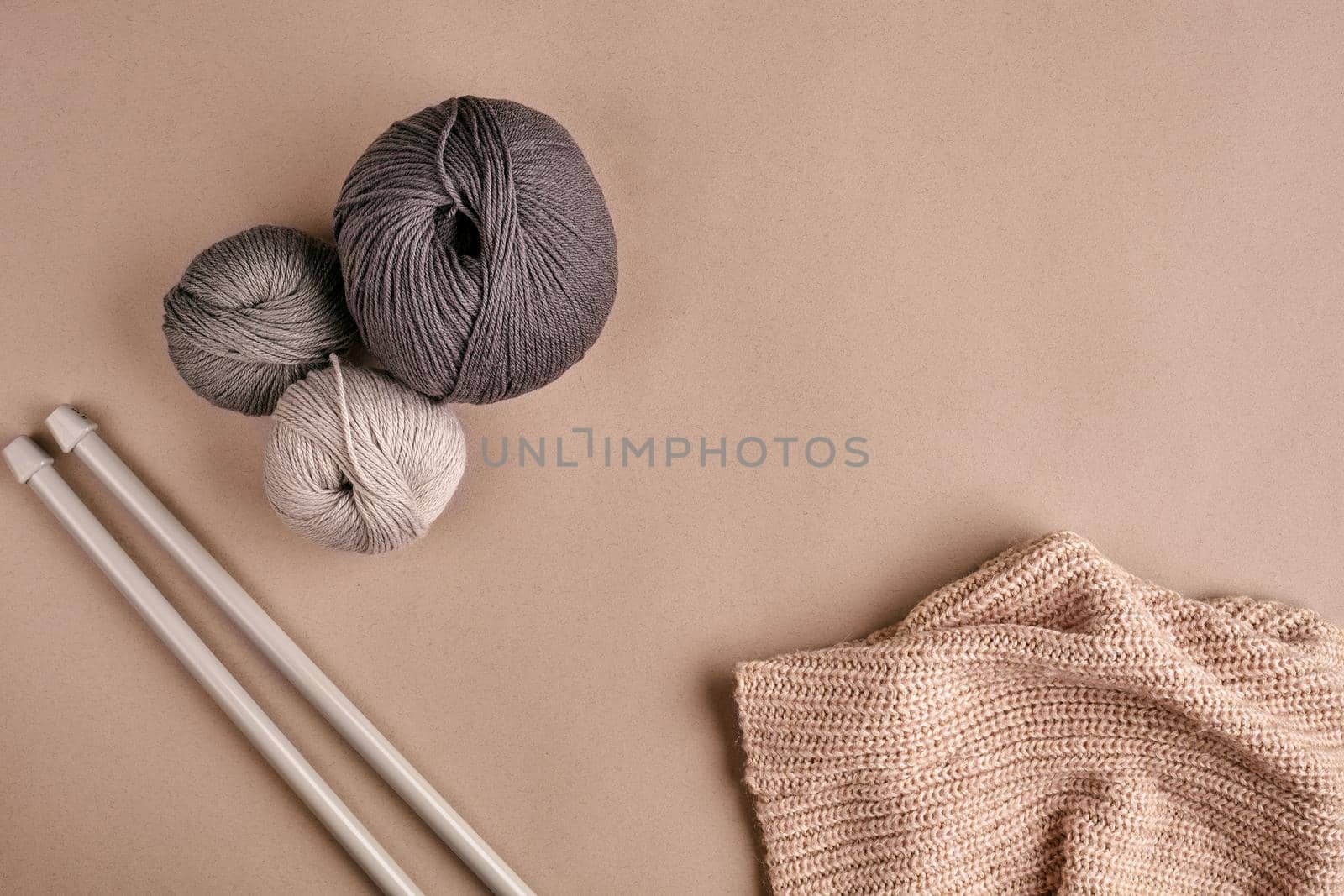 Knitted from a gray yarn sweater and thread for knitting closeup. Knitting as a hobby. Accessories for knitting. by nazarovsergey