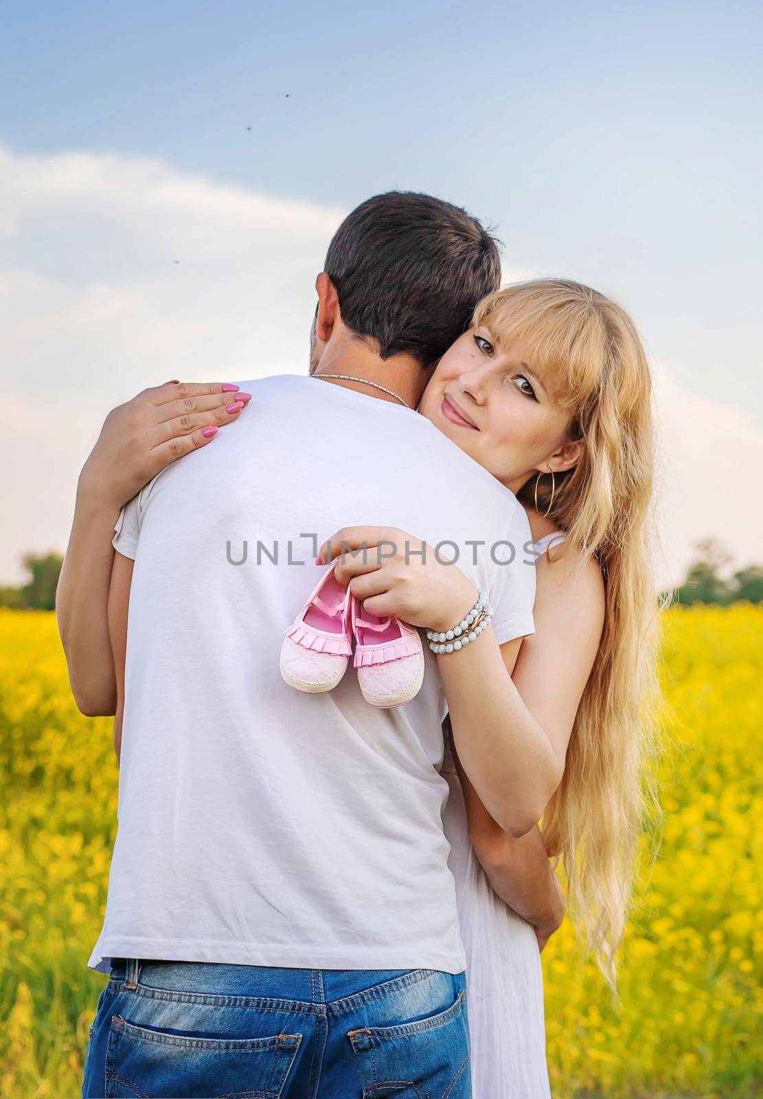 pregnant woman and man hold baby shoes. Selective focus. nature.