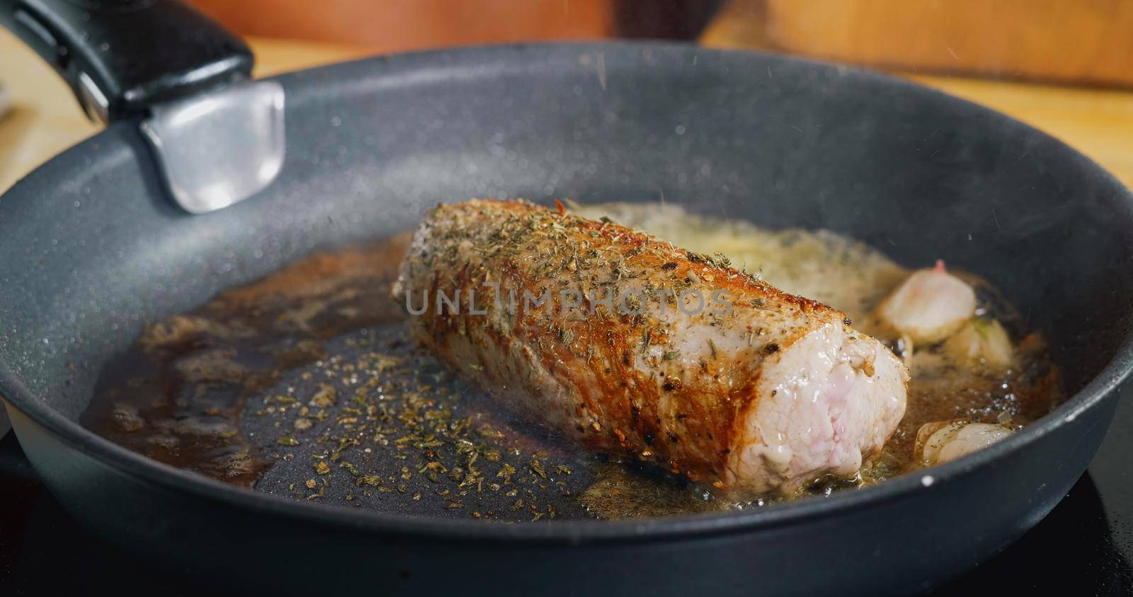 Seasoning with Falling Herbs on Fresh Fried Pork Meat. Professional Cooking. Spectacular images from kitchen.