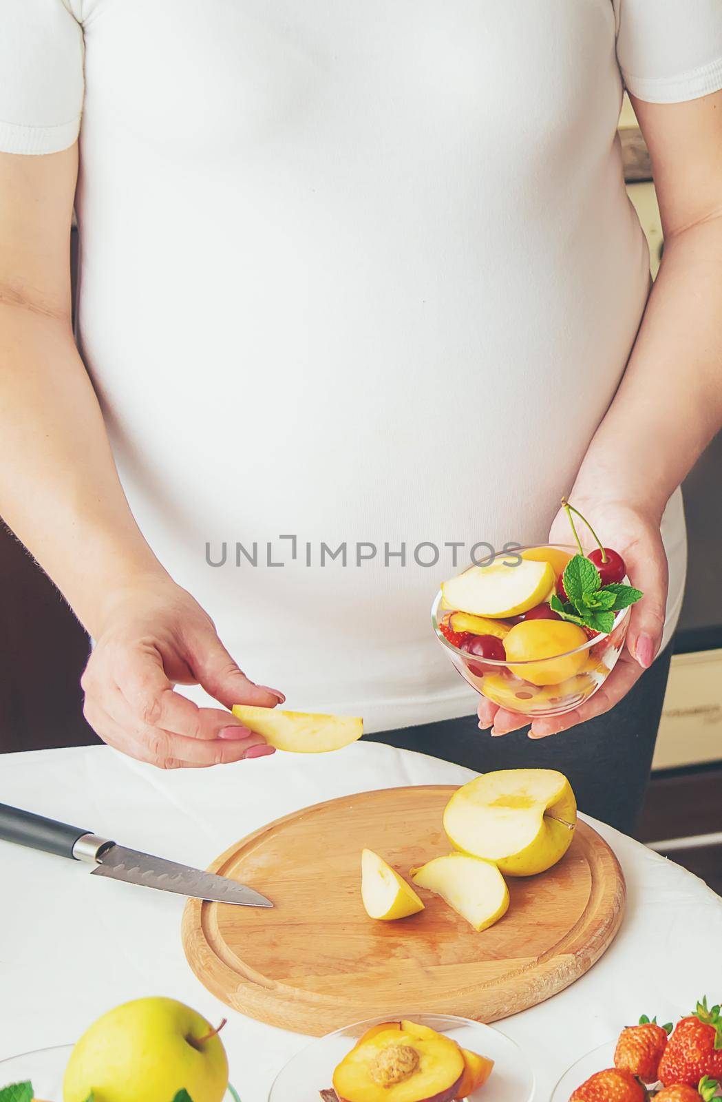 A pregnant woman eats fruit. Selective focus. food.