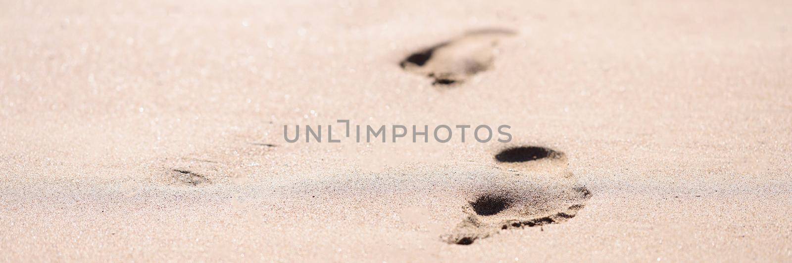 Barefoot prints on wet sand on beach closeup background. Vacation at sea concept
