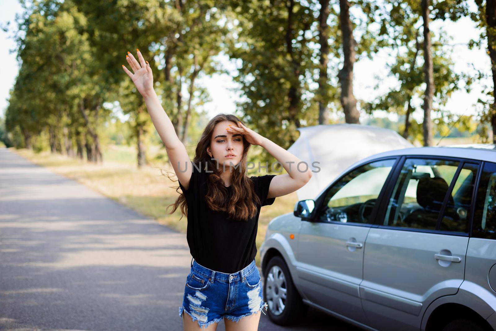 Girl stands near her broken car stops other drivers by VitaliiPetrushenko
