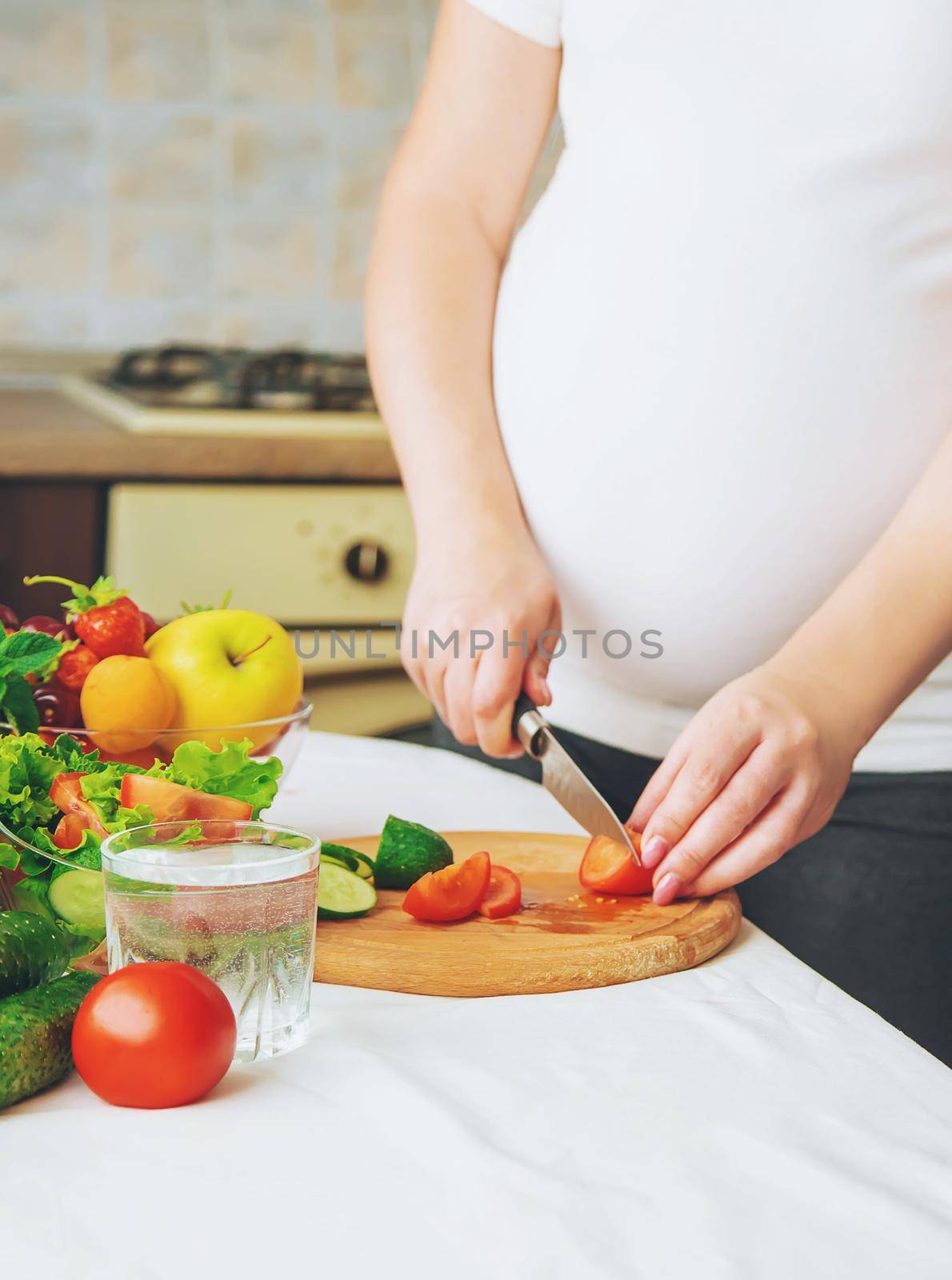 A pregnant woman eats vegetables and fruits. Selective focus. Food.