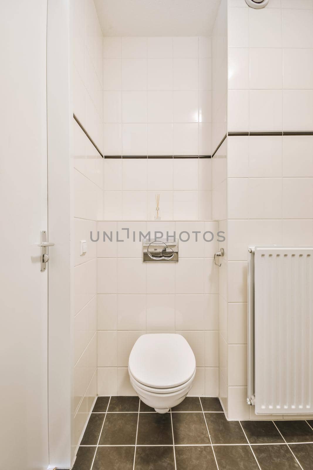 Bathtub with glass shower placed in corner near sink and toilet in small light bathroom with white tile walls