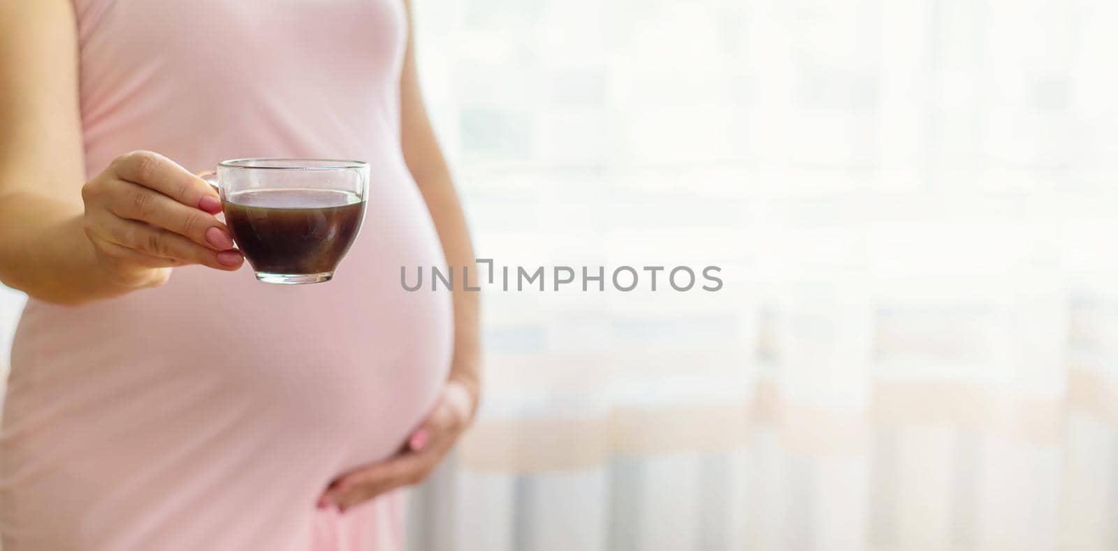 A pregnant woman is drinking coffee. Selective focus. by yanadjana