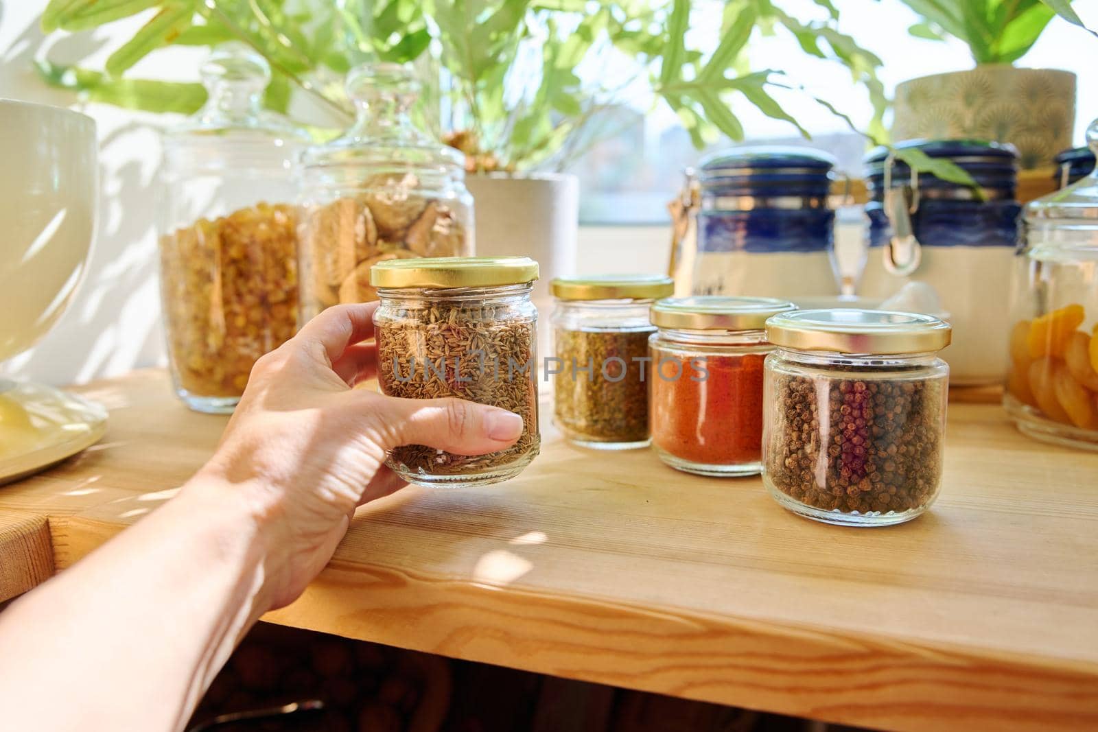 Jars with different spices in the kitchen, zira close-up. Cooking at home, stocking food, household