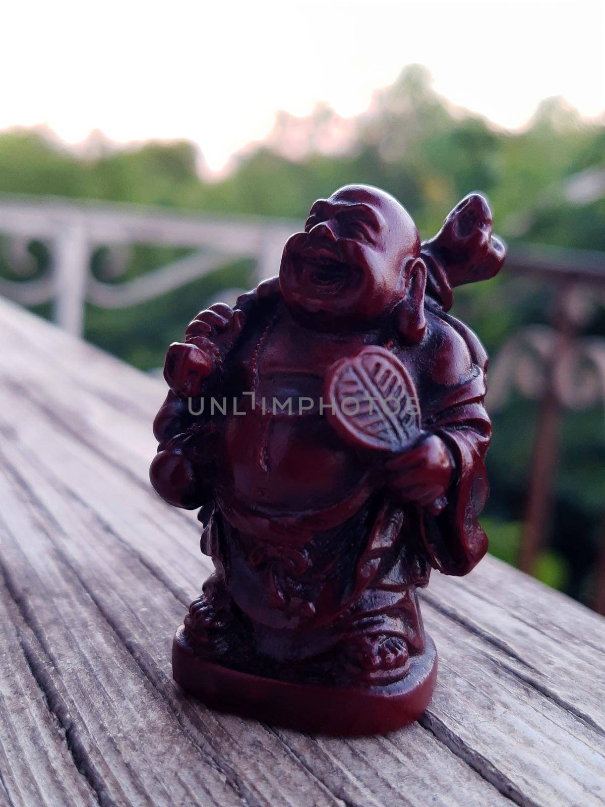 Netsuke Hotei from ceramics on a gray background close-up.