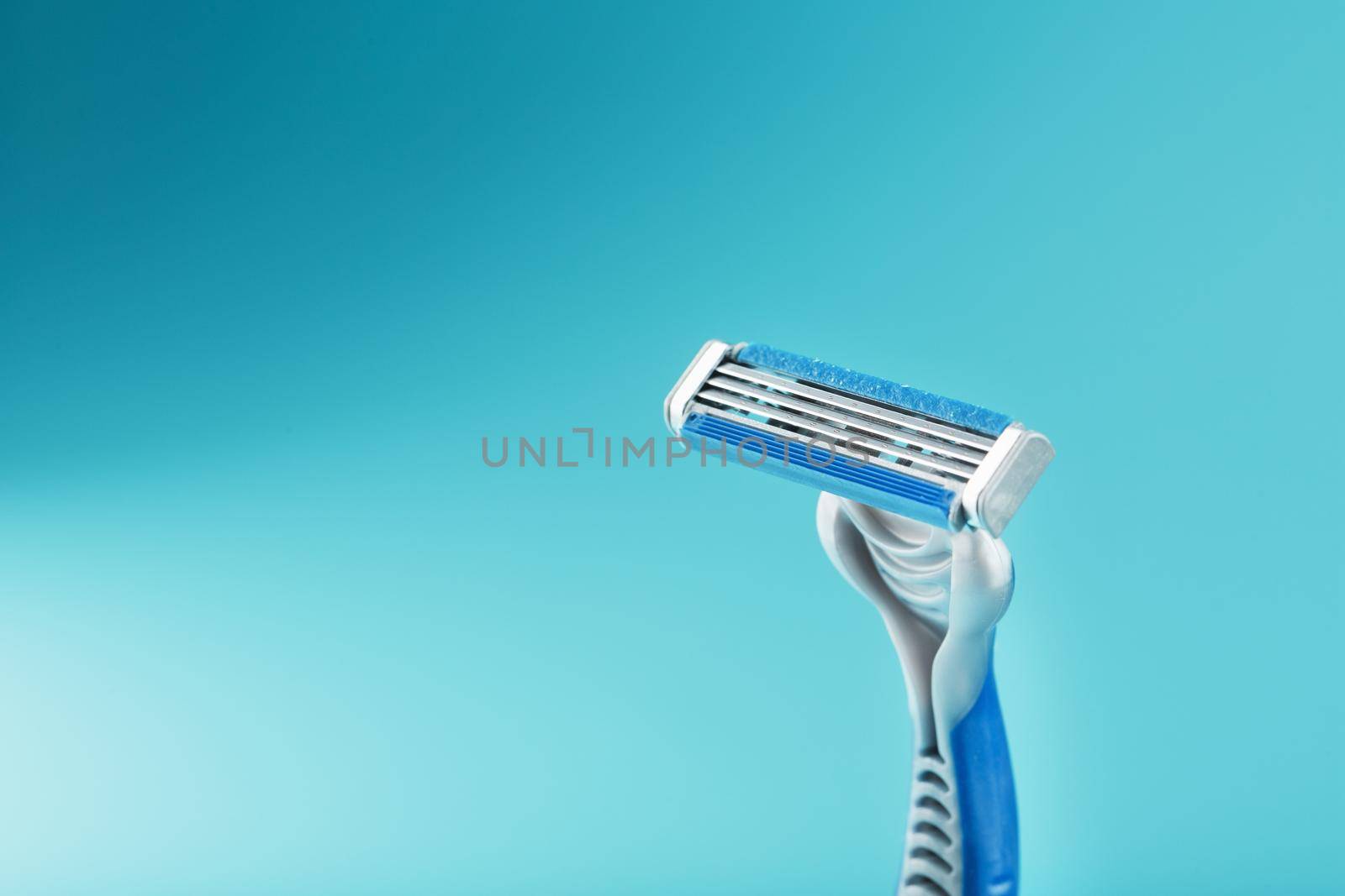 Shaving machine with three blades on a blue background close-up free space