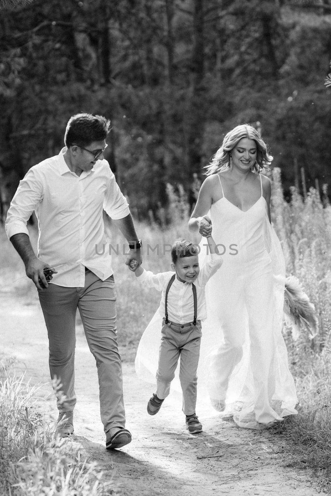 happy family three dad mom and son on a walk in the woods