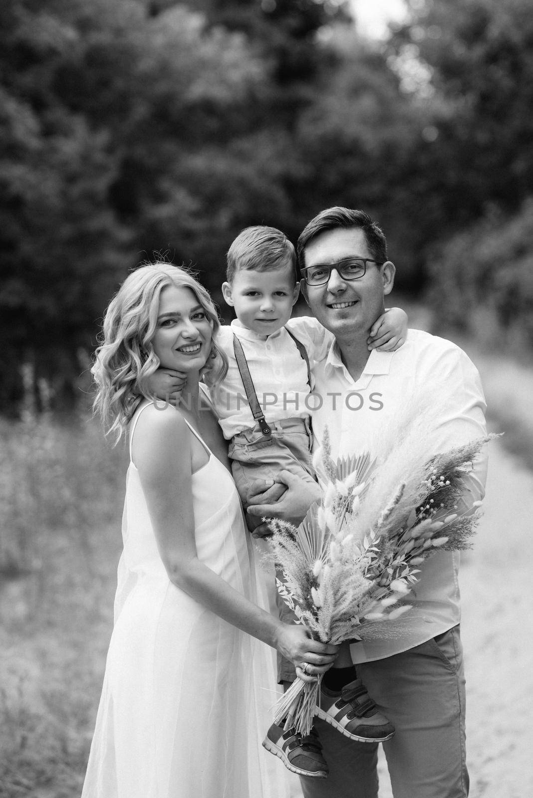 happy family three dad mom and son on a walk in the woods