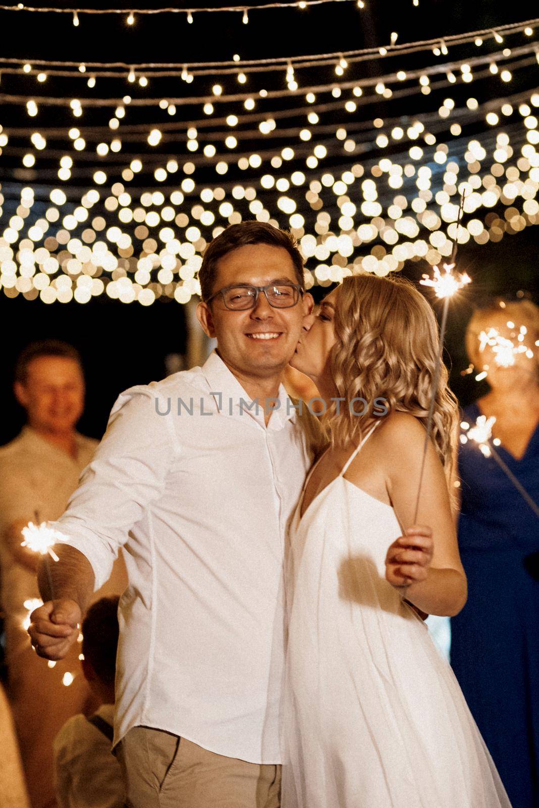 sparklers at the wedding of the newlyweds in the hands of joyful guests