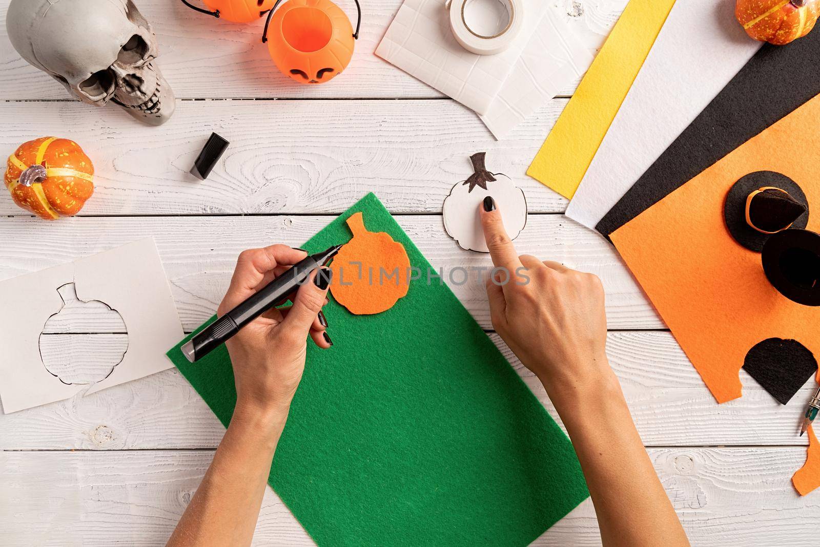 Happy Halloween concept. Step by step instruction of making halloween bookmark DIY pumpkin craft. Step 4 - draw out a green part of a pumpkin. Top view flat lay