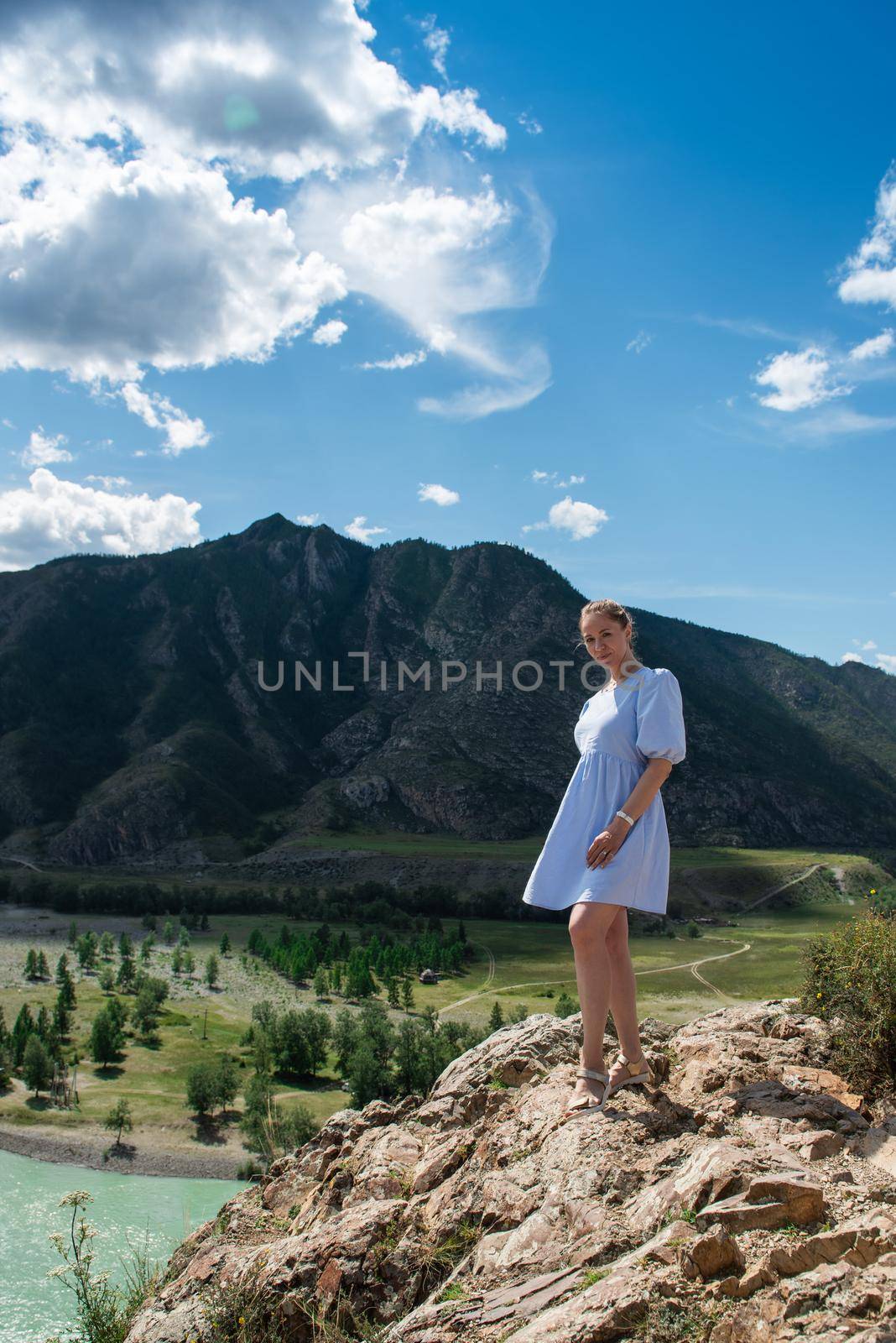 Woman in blue dress on the confluence of two rivers Katun and Chuya in Altai mountains, beauty summer day