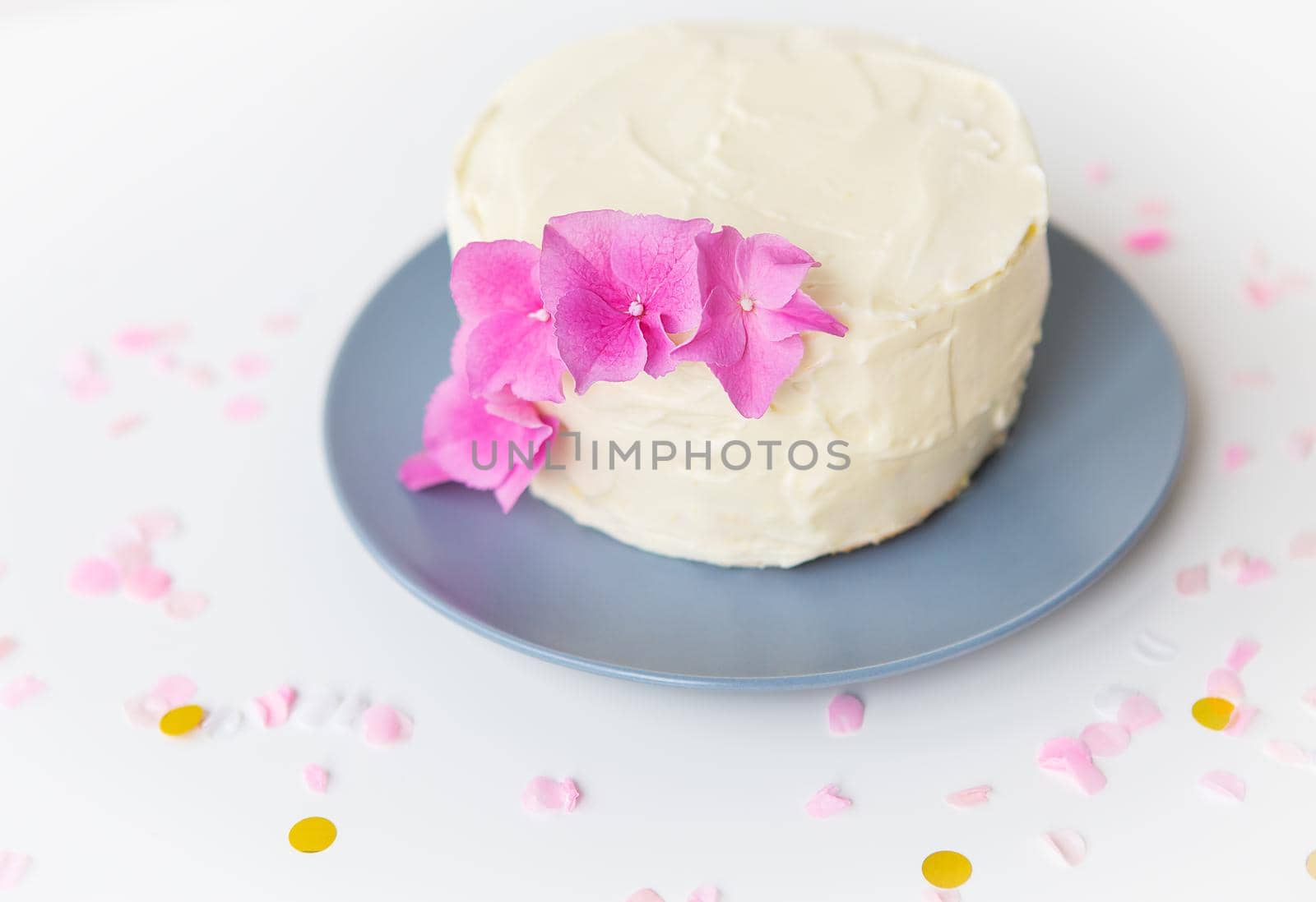 Very beautiful small white bento cake, decorated with fresh flowers of pink hydrangeas. Holiday and fun concept