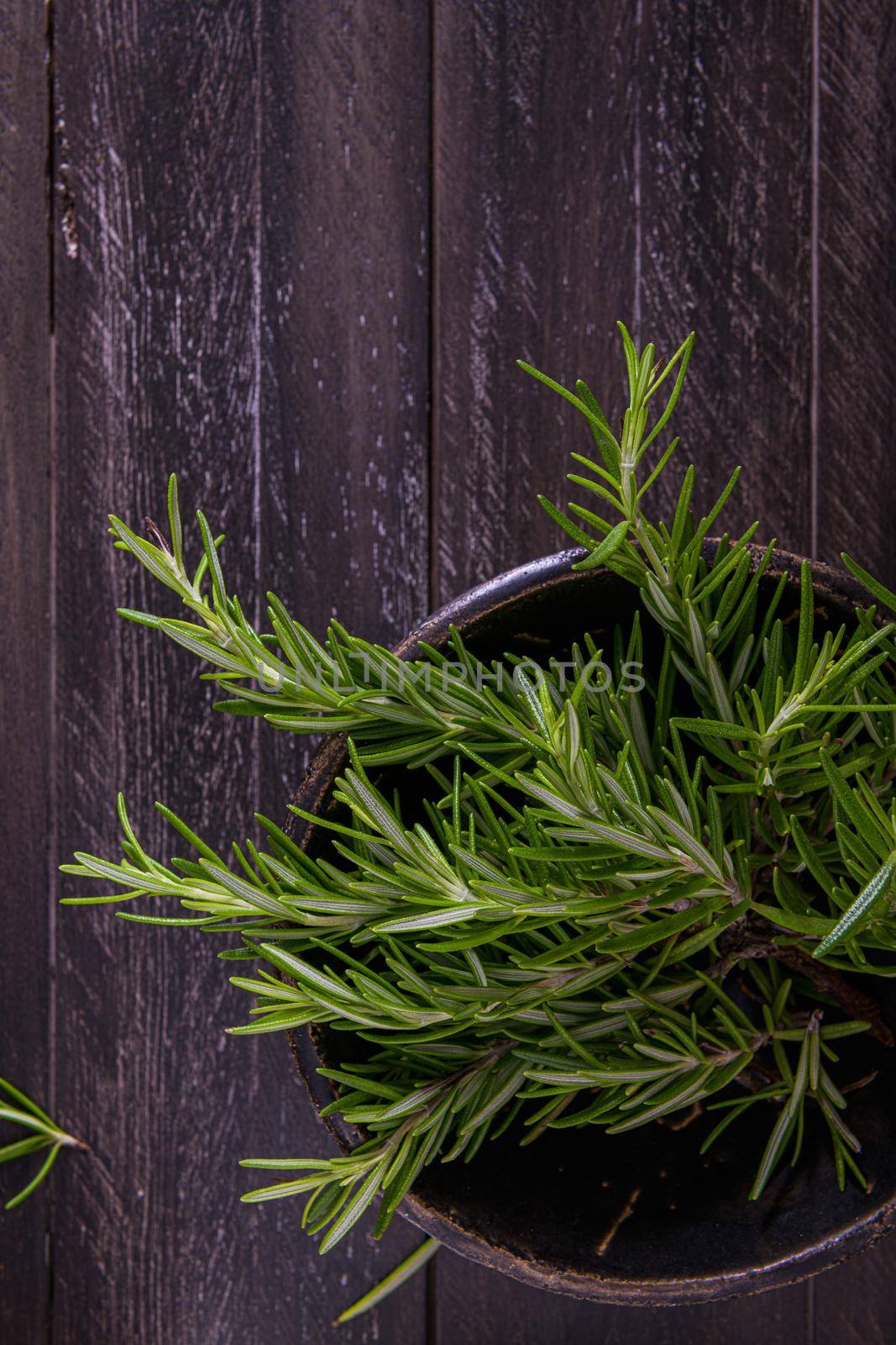 Bowl of rosemary on wooden background by homydesign