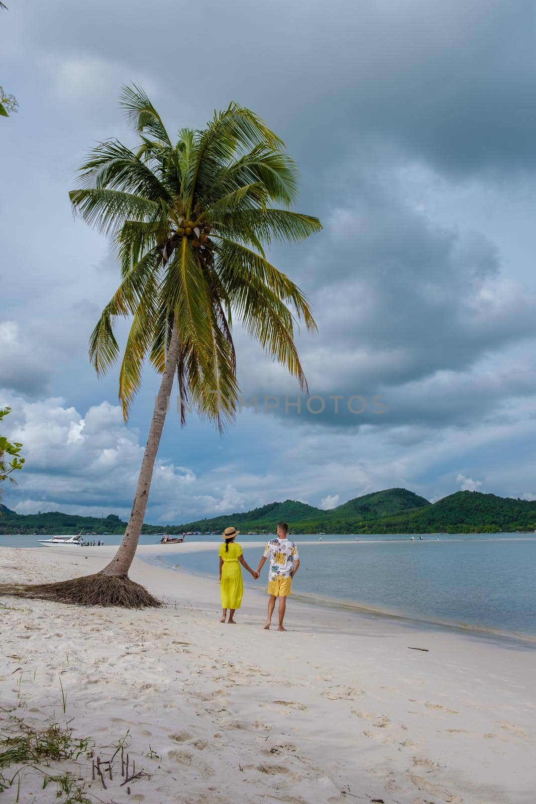 couple men and women walking on the beach at the Island Koh Yao Yai thailand, beach with white sand and palm trees by fokkebok