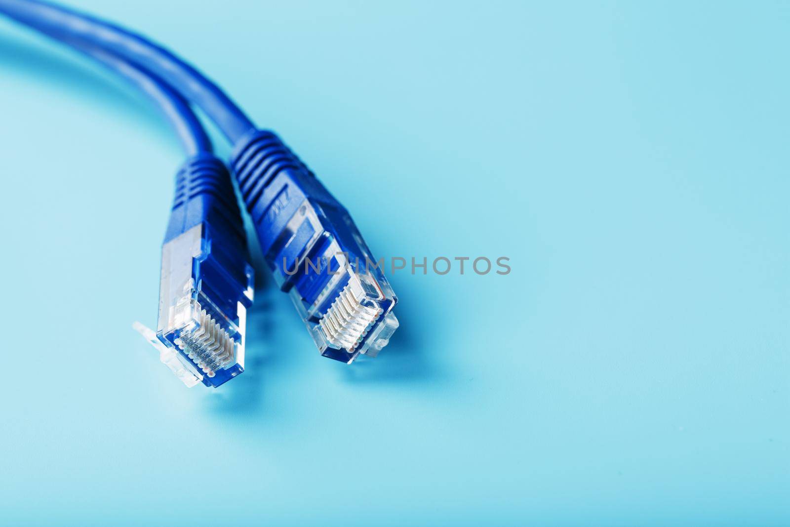 Ethernet Cable connector Patch cord cord close-up on a blue background with free space by AlexGrec