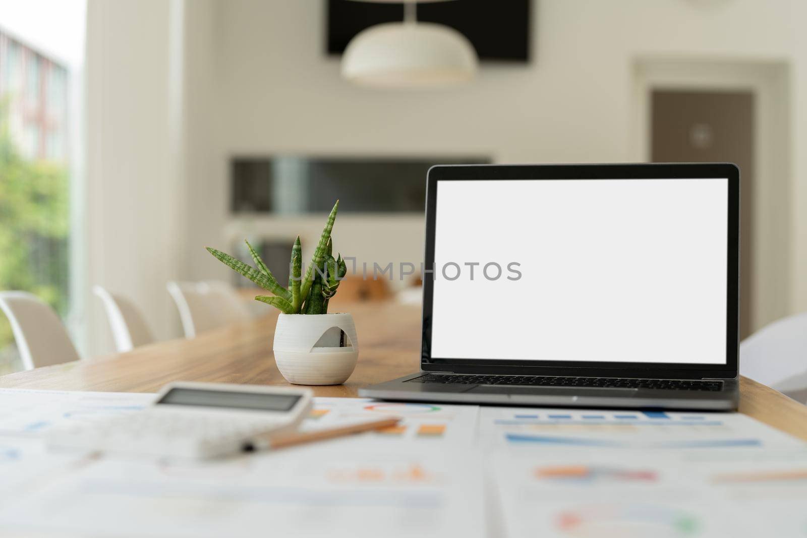 modern laptop computer with blank screen at workplace in office. finance report and calculator accounting on wooden table.