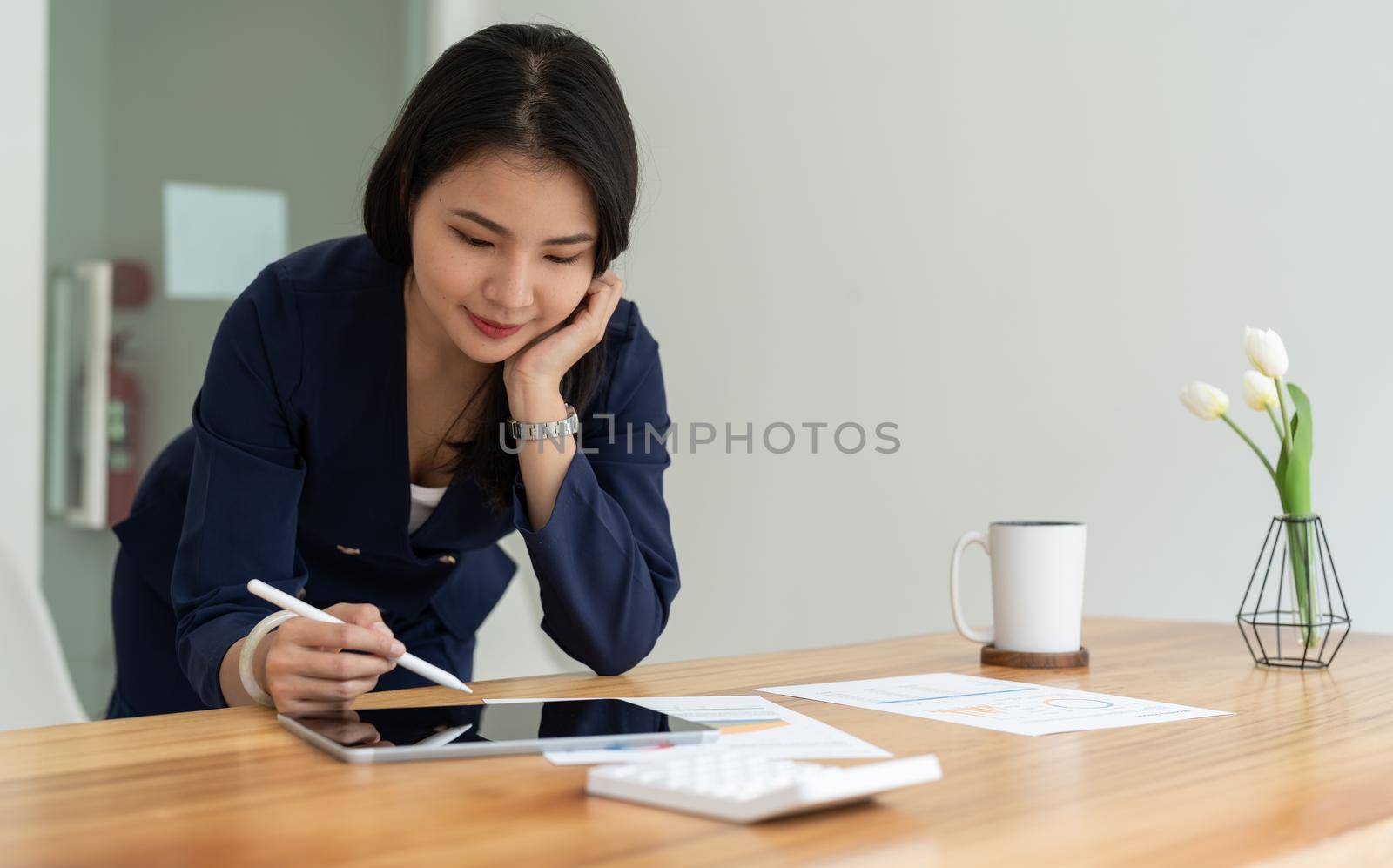 Close up hand of businesswoman using stylus pen signing contract on digital tablet on office table. Business manager proofing e-document, electronic signature, e-signing mobile app.