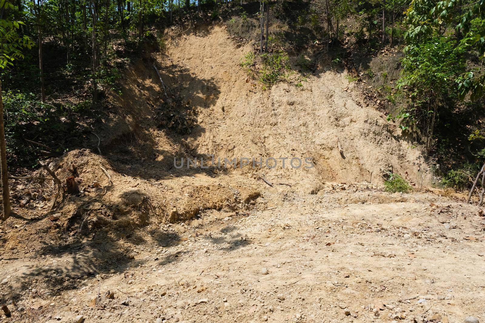 Surface of high soil canyon cliffs has many rounded pebbles scattered in the soil at Pha Chor, a famous tourist attraction in northern Thailand. by TEERASAK