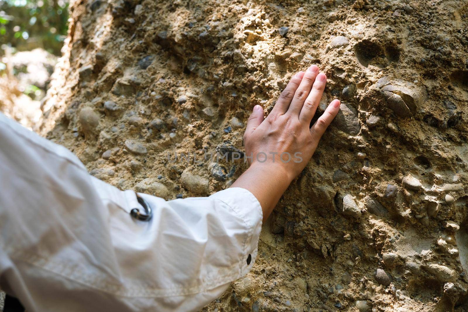 Asian female geologist researcher touches rocks by hand to analyze surface in Mae Wang Natural Park, Thailand. Exploration Geologist in the Field by TEERASAK