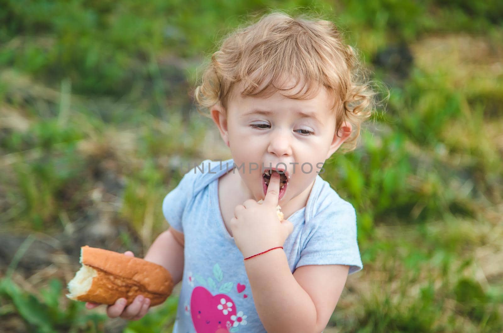 A child eats bread in the park. Selective focus. kid.