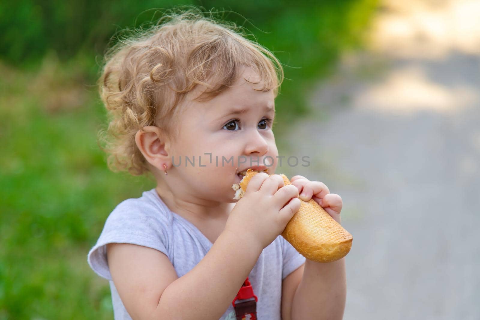 A child eats bread in the park. Selective focus. kid.