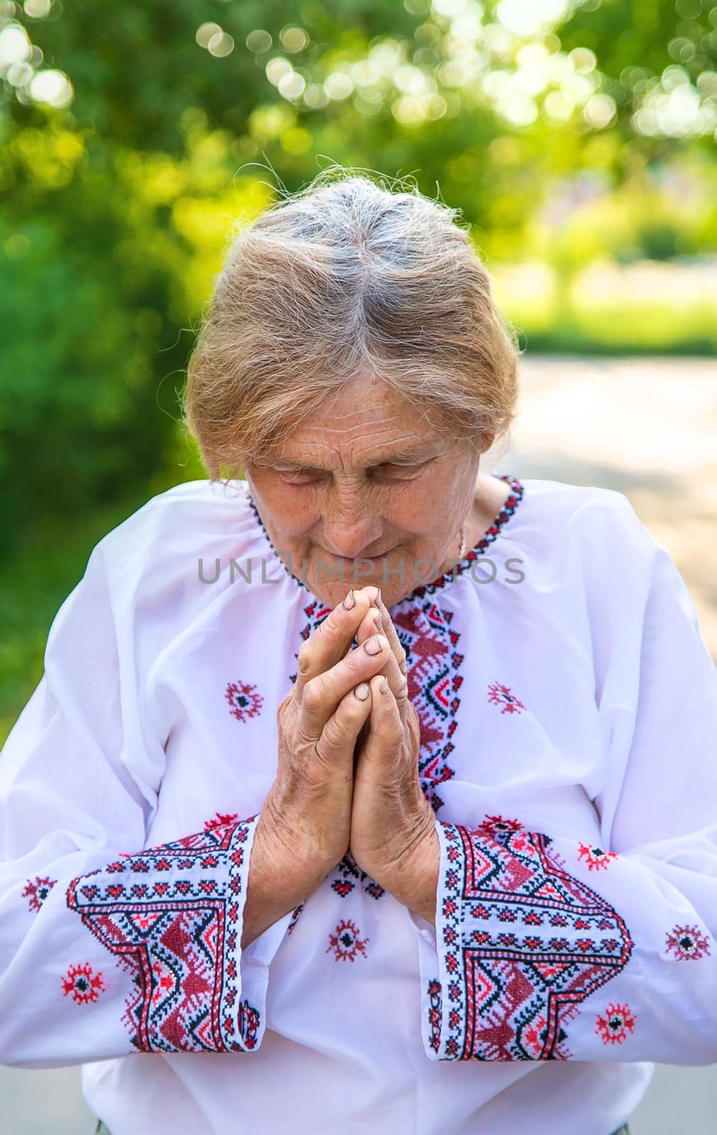 Grandmother in Ukrainian embroidered clothes. Selective focus. Nature.