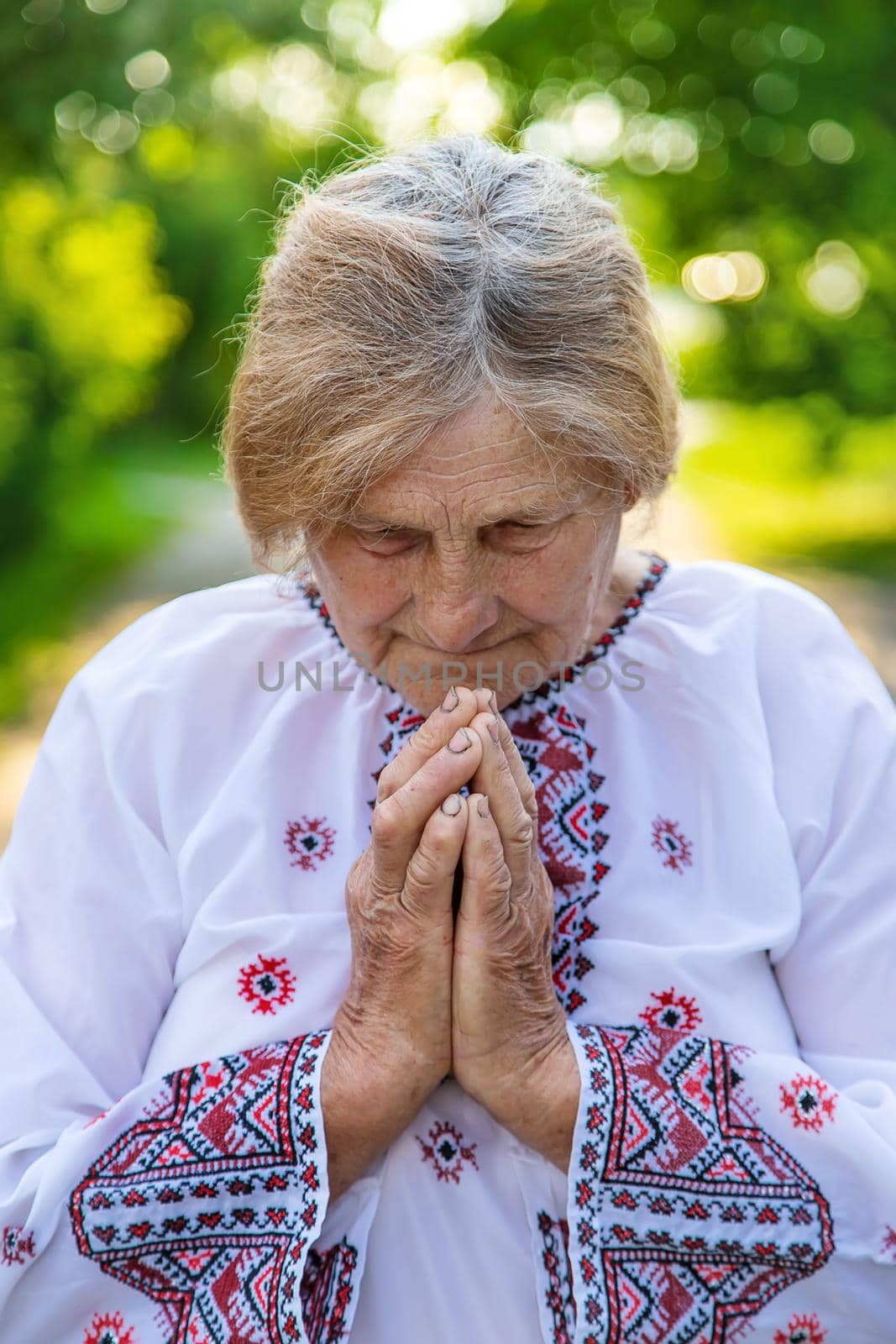 Grandmother in Ukrainian embroidered clothes. Selective focus. Nature.