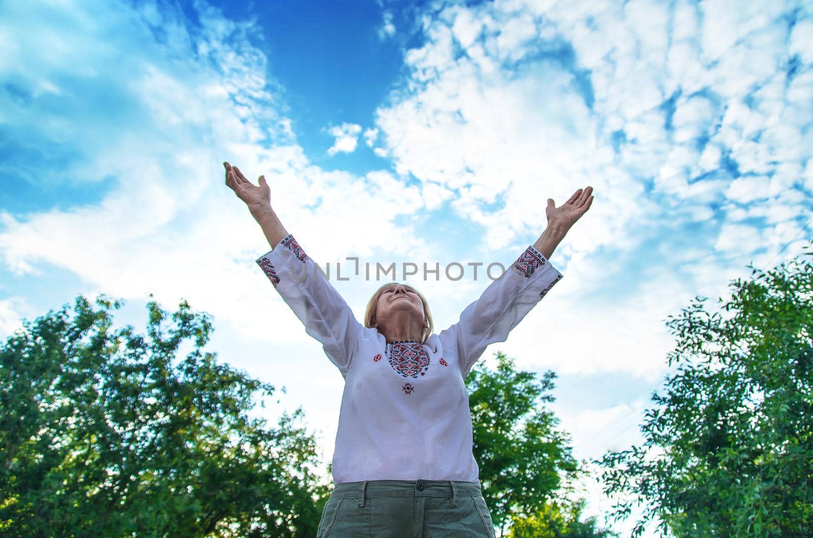 Grandmother in Ukrainian embroidered clothes. Selective focus. Nature.