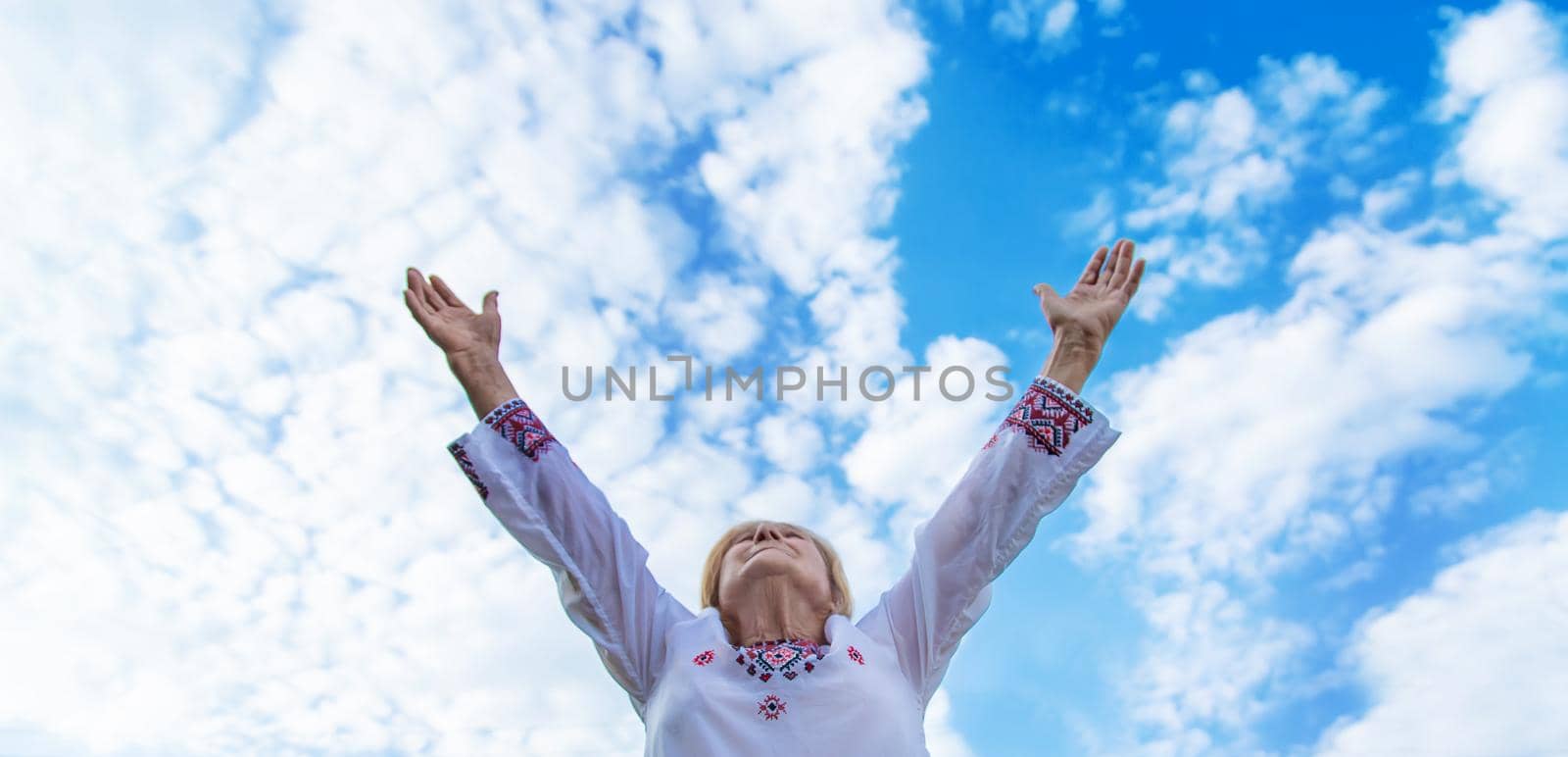 Grandmother in Ukrainian embroidered clothes. Selective focus. Nature.