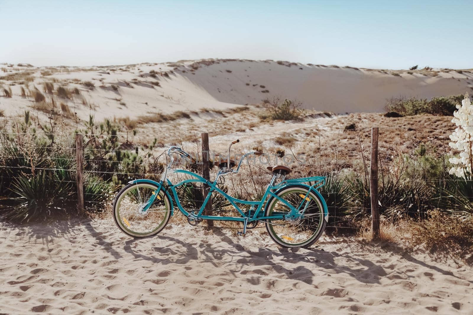 Blue bicycle standing on dune on the sea coast
