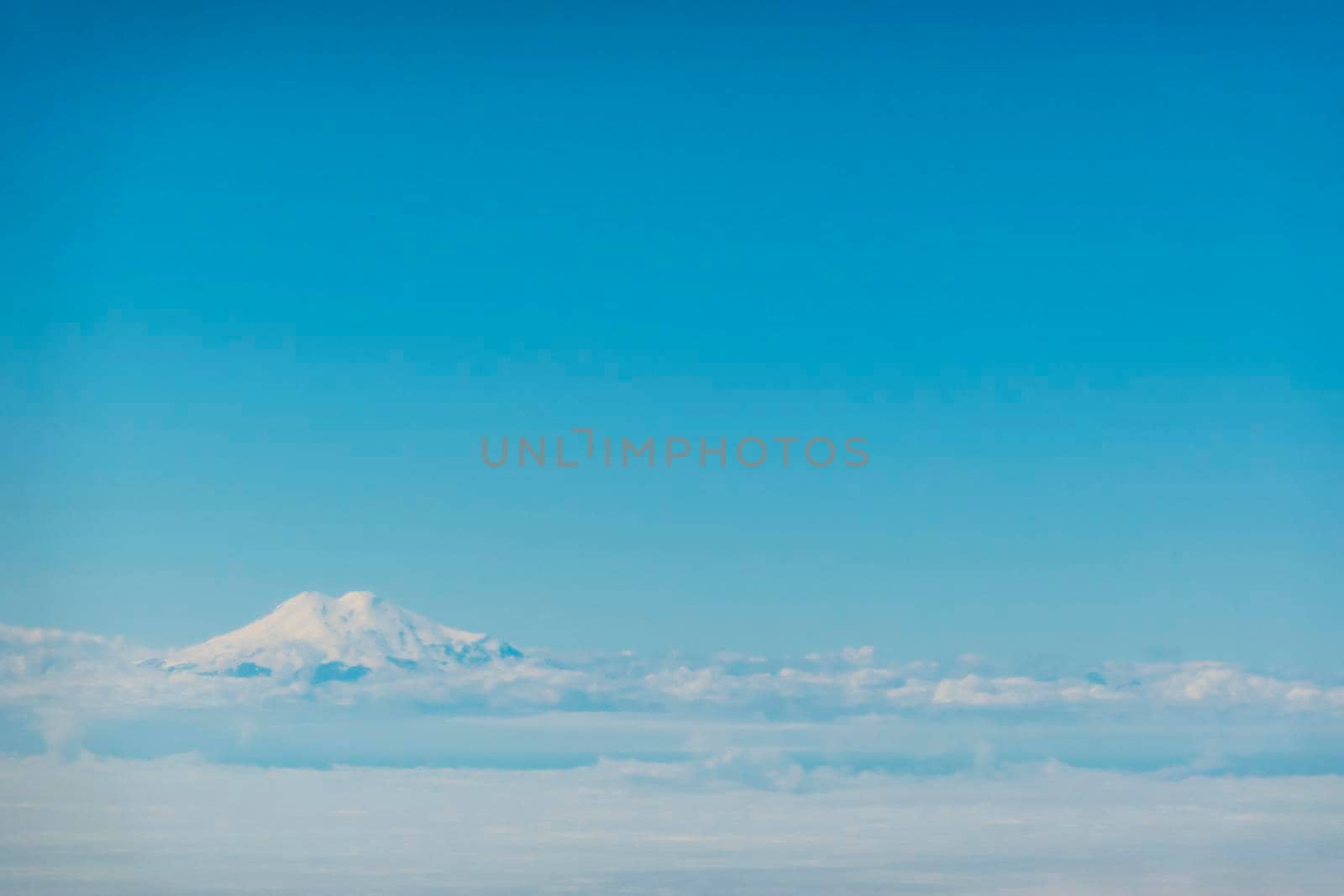 Aerial view over Elbrus, Karachay Cherkessia. the sky with clouds, below the level of the top of Elbrus. A mountain like a cloud. High quality photo
