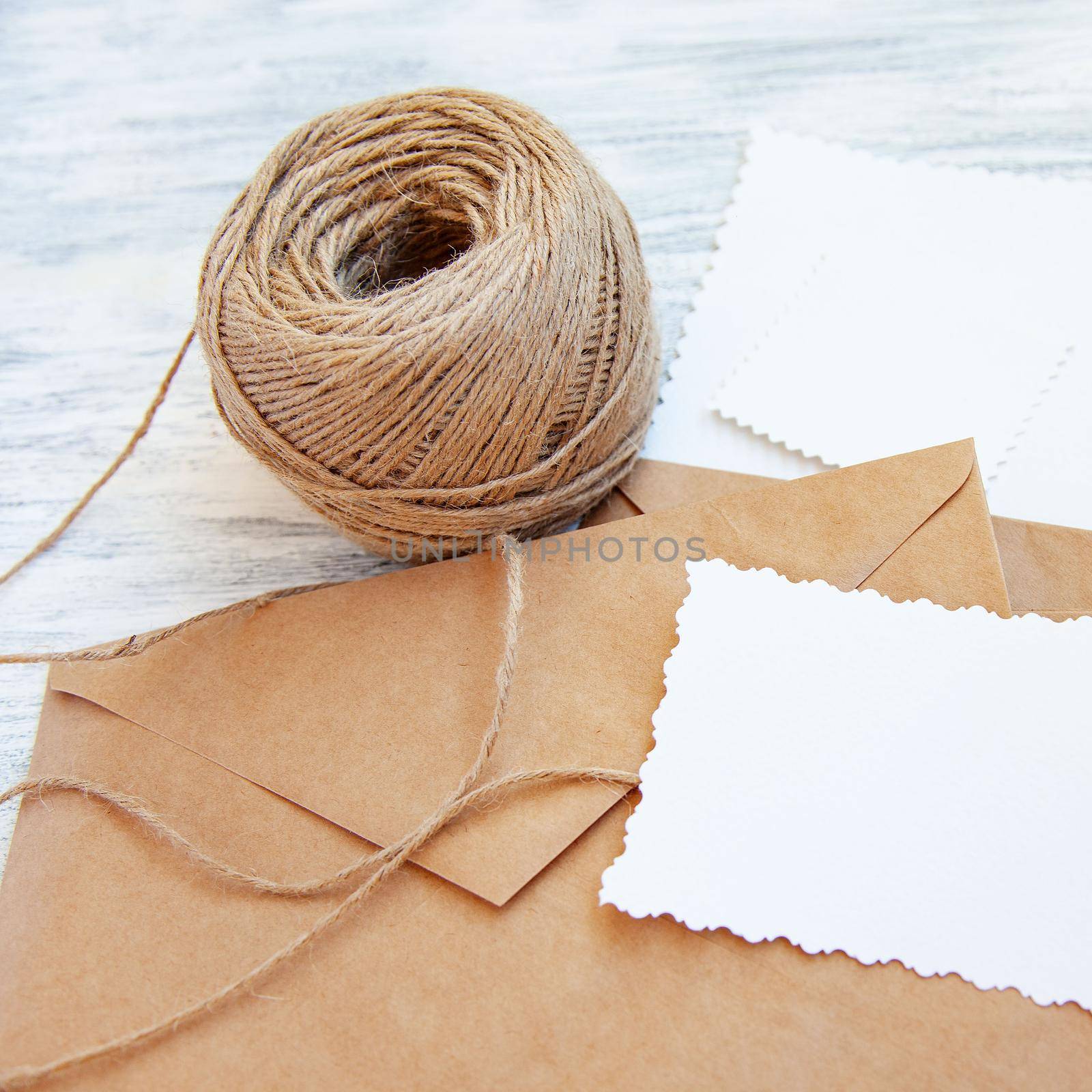 Light stillife with brown rough paper envelopes, skein of cord and blank white empty card