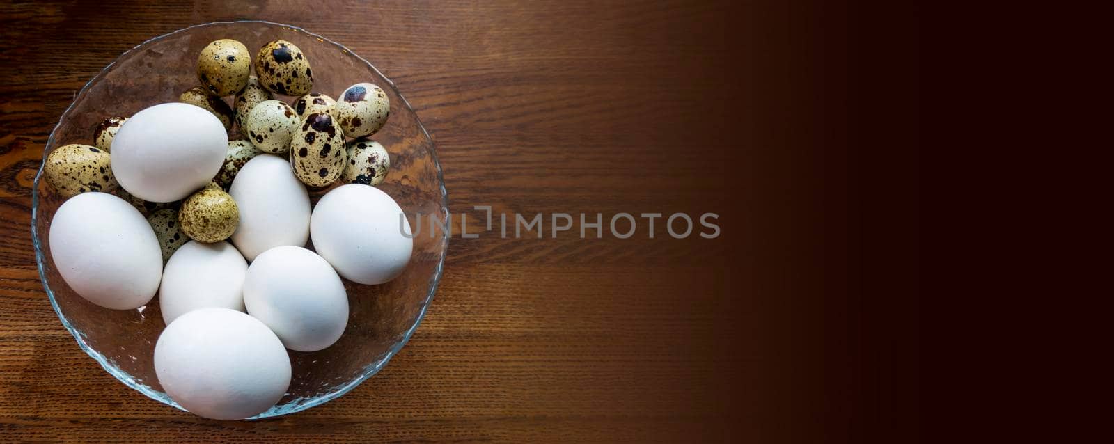 background of quail spotted and chicken white eggs in a saucepan. Quail eggs on white dish, There are many sizes and patterns are different. bunner with copy space