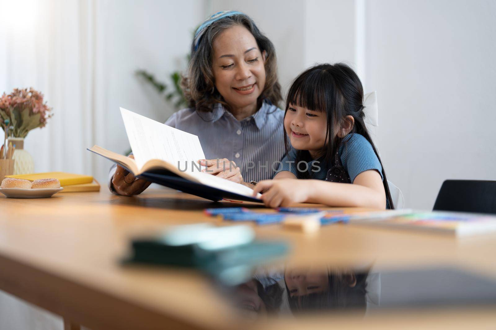 grandchild granddaughter grandma grandmother reading book girl senior.