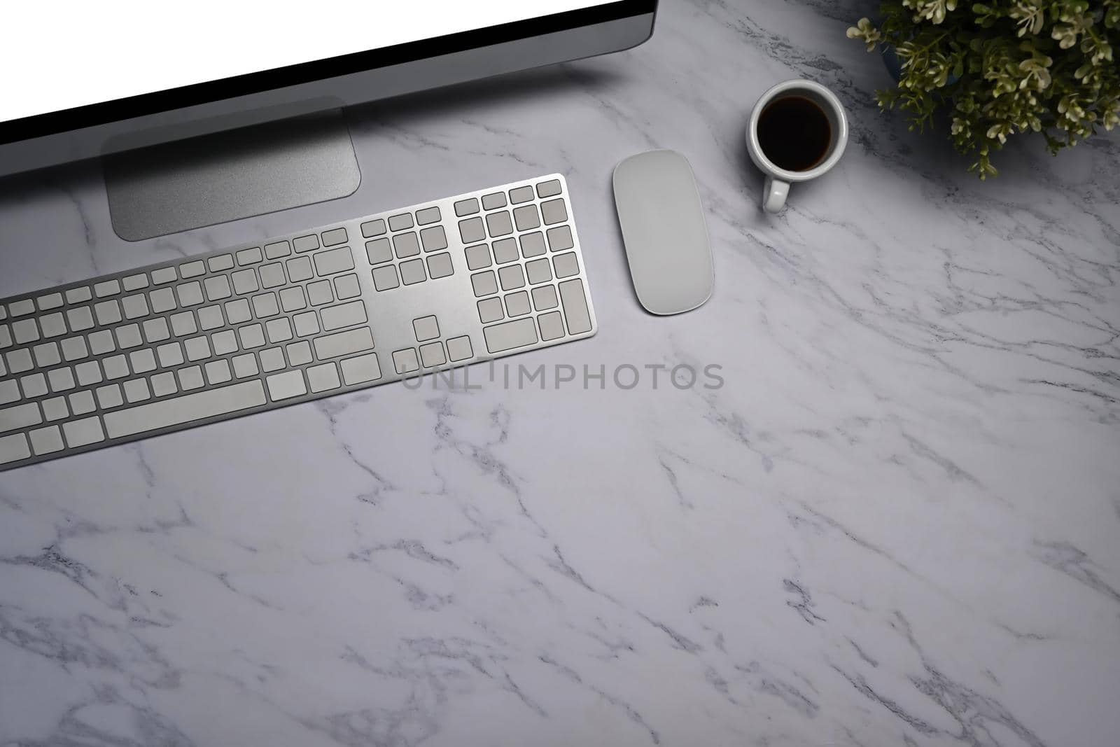 Modern computer, coffee cup, wireless keyboard and mouse on marble background.
