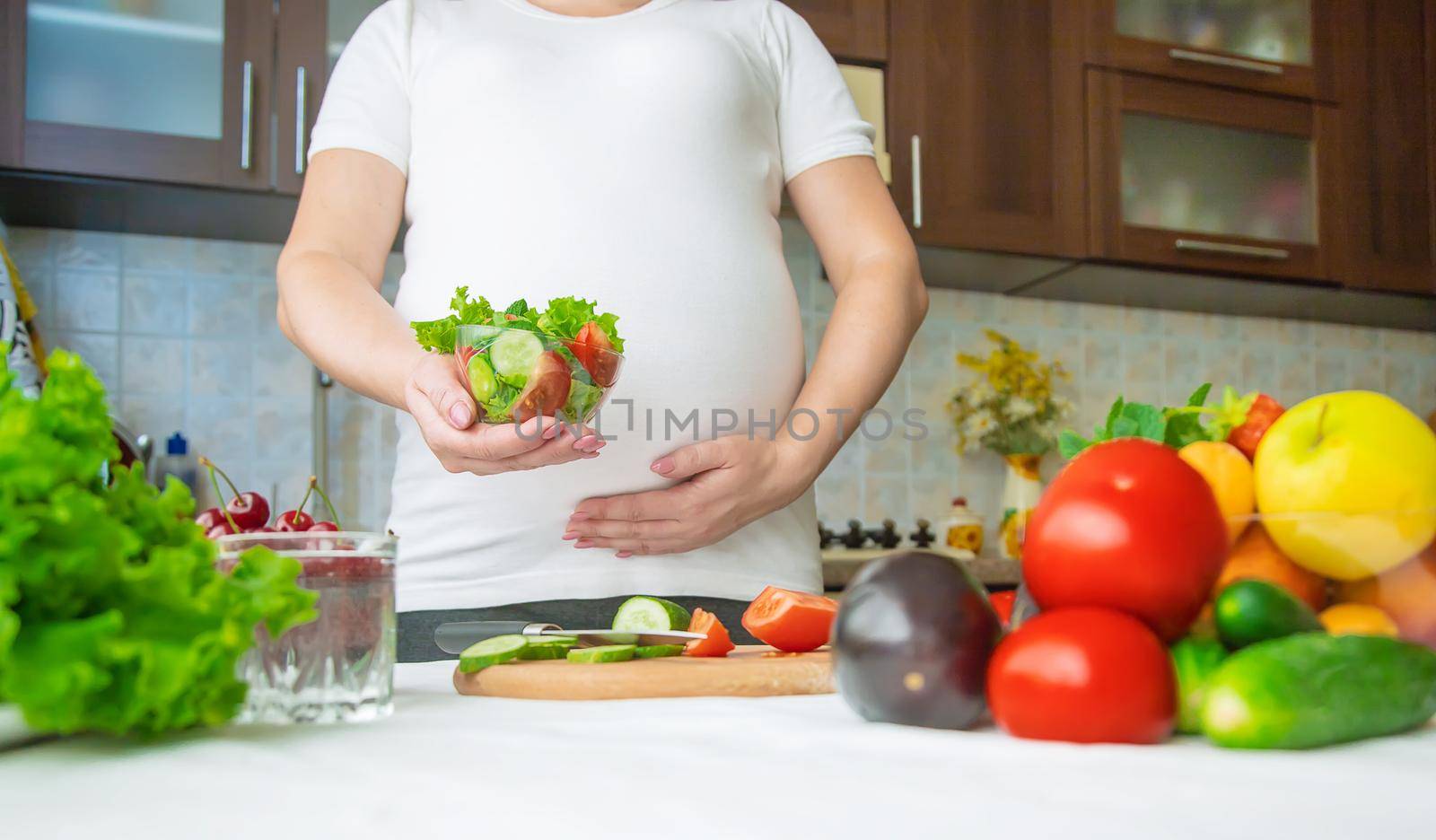 A pregnant woman eats vegetables and fruits. Selective focus. Food.