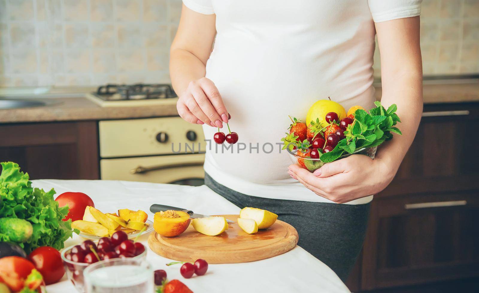 A pregnant woman eats vegetables and fruits. Selective focus. Food.