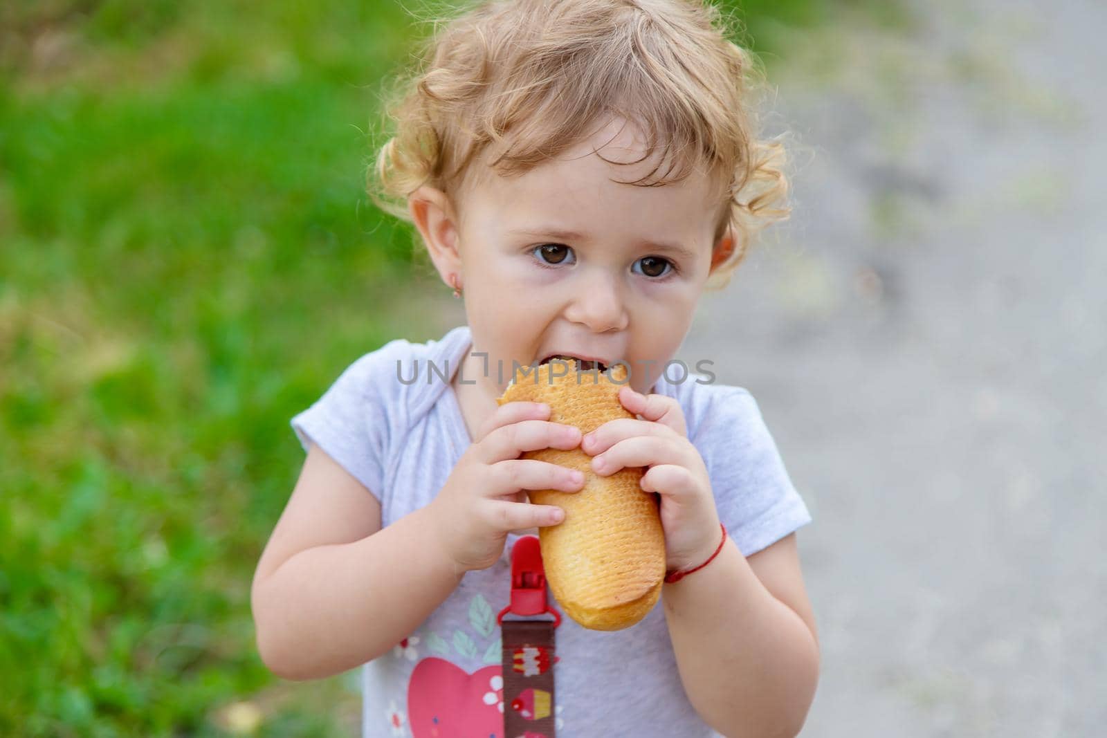 A child eats bread in the park. Selective focus. kid.