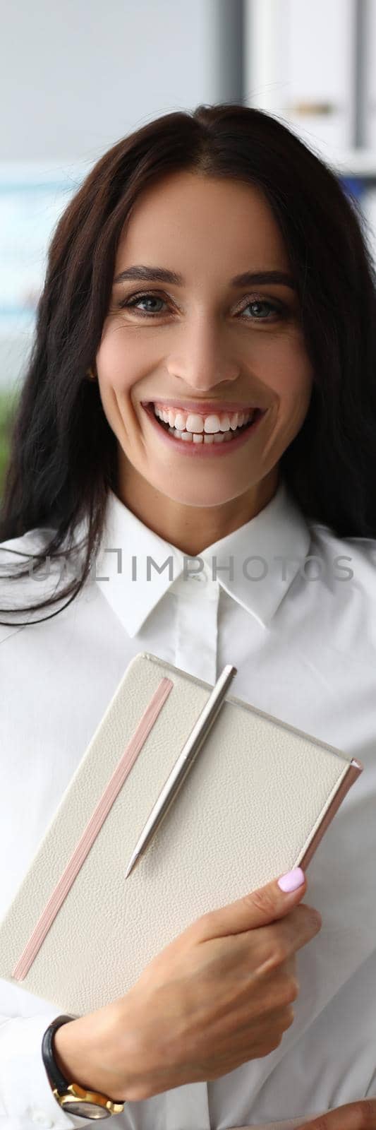 Portrait of successful smiling businesswoman holding notepad. Business company and work concept