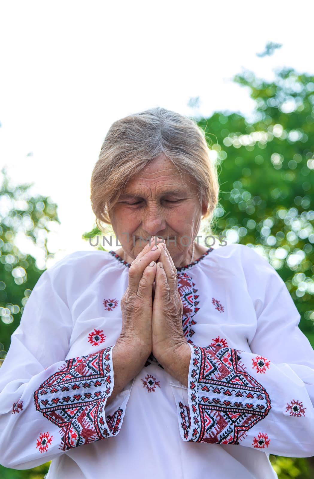 Grandmother in Ukrainian embroidered clothes. Selective focus. by yanadjana