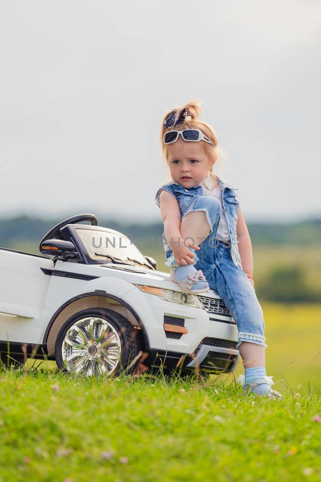 little girl standing near her baby car