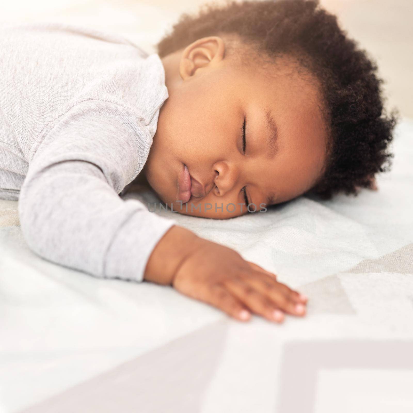Sweet little dreamer. Shot of a little baby boy sleeping on a bed. by YuriArcurs