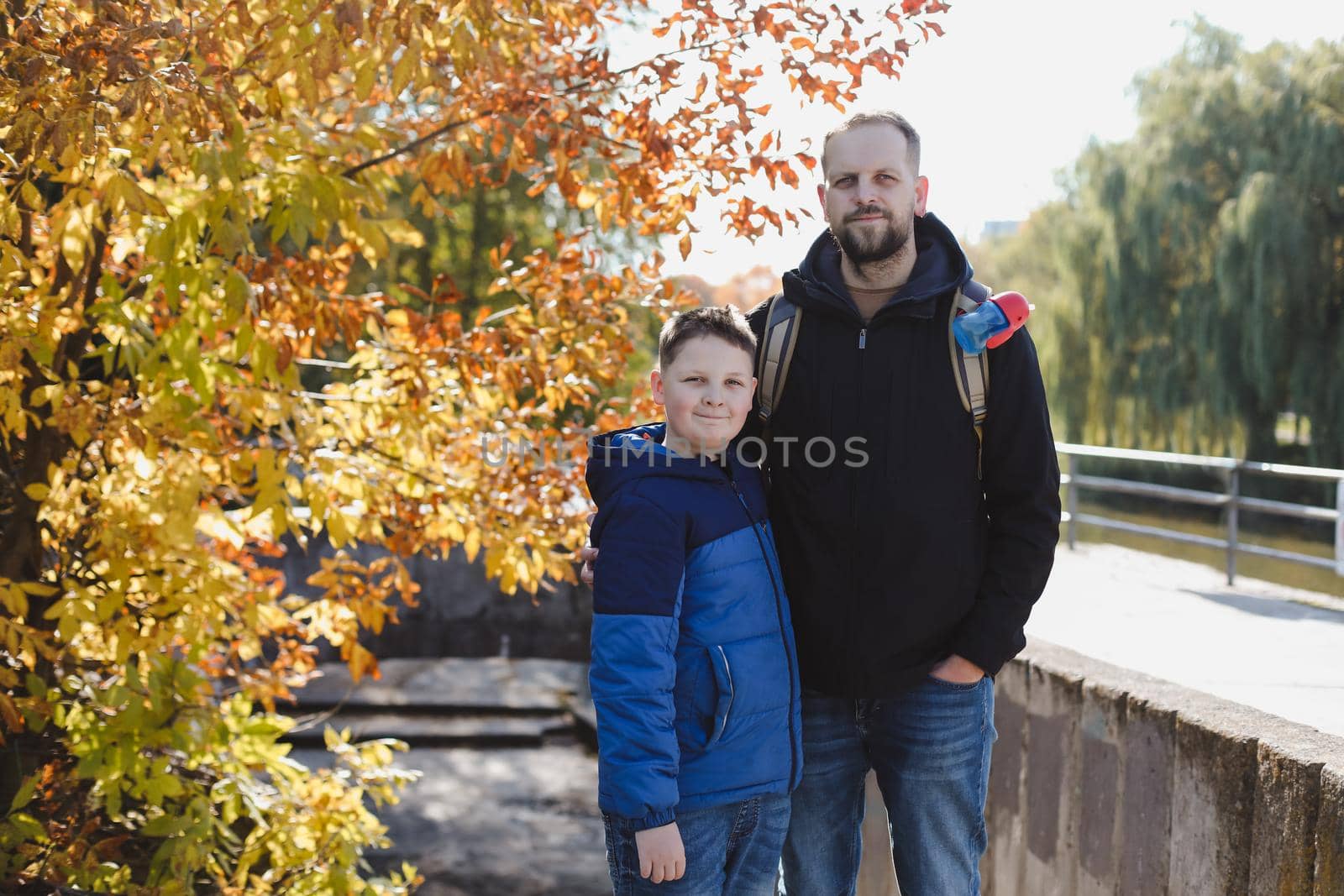 portrait of a happy father and son outdoors in autumn by paralisart
