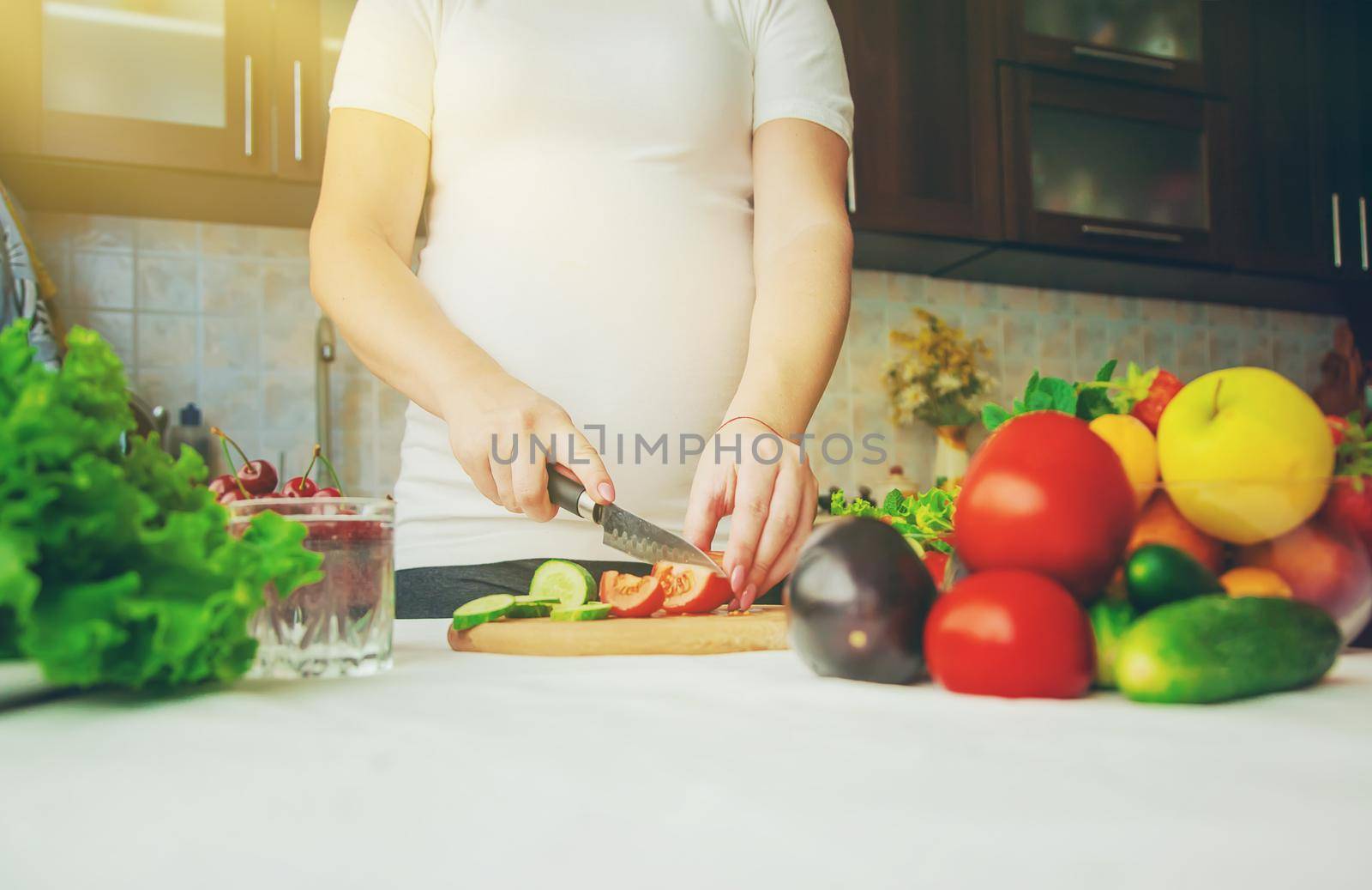 A pregnant woman eats vegetables and fruits. Selective focus. Food.