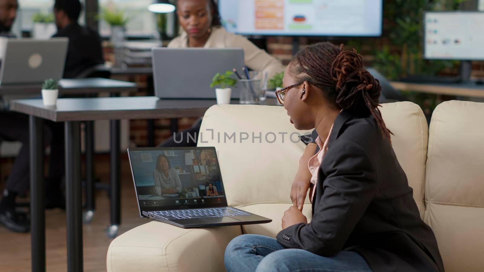 Female worker attending business meeting on videocall, using remote internet communication to talk to colleagues. Young woman chatting on online video teleconference, telecommunication.